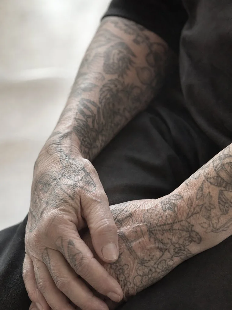 Two hands and forearms covered in dense fine-line blackwork